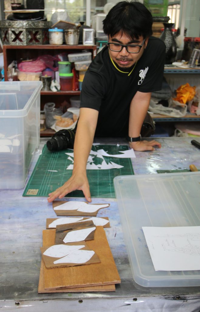 ช่างติดลายบนไม้จันทน์ก่อนฉลุลายตามแบบ