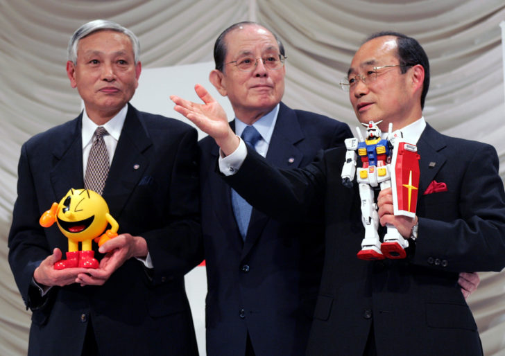 FILE PHOTO- Japanese toy maker Bandai Co President Takasu poses for photographers with Nakamura, chairman and founder of videogame company Namco Ltd, creator of