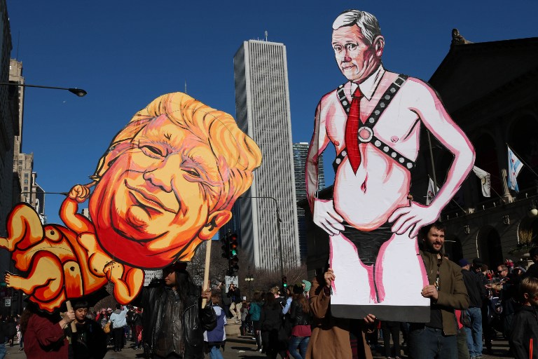 ผู้ชุมนุมชูภาพล้อเลียนที่นครชิคาโก / AFP 