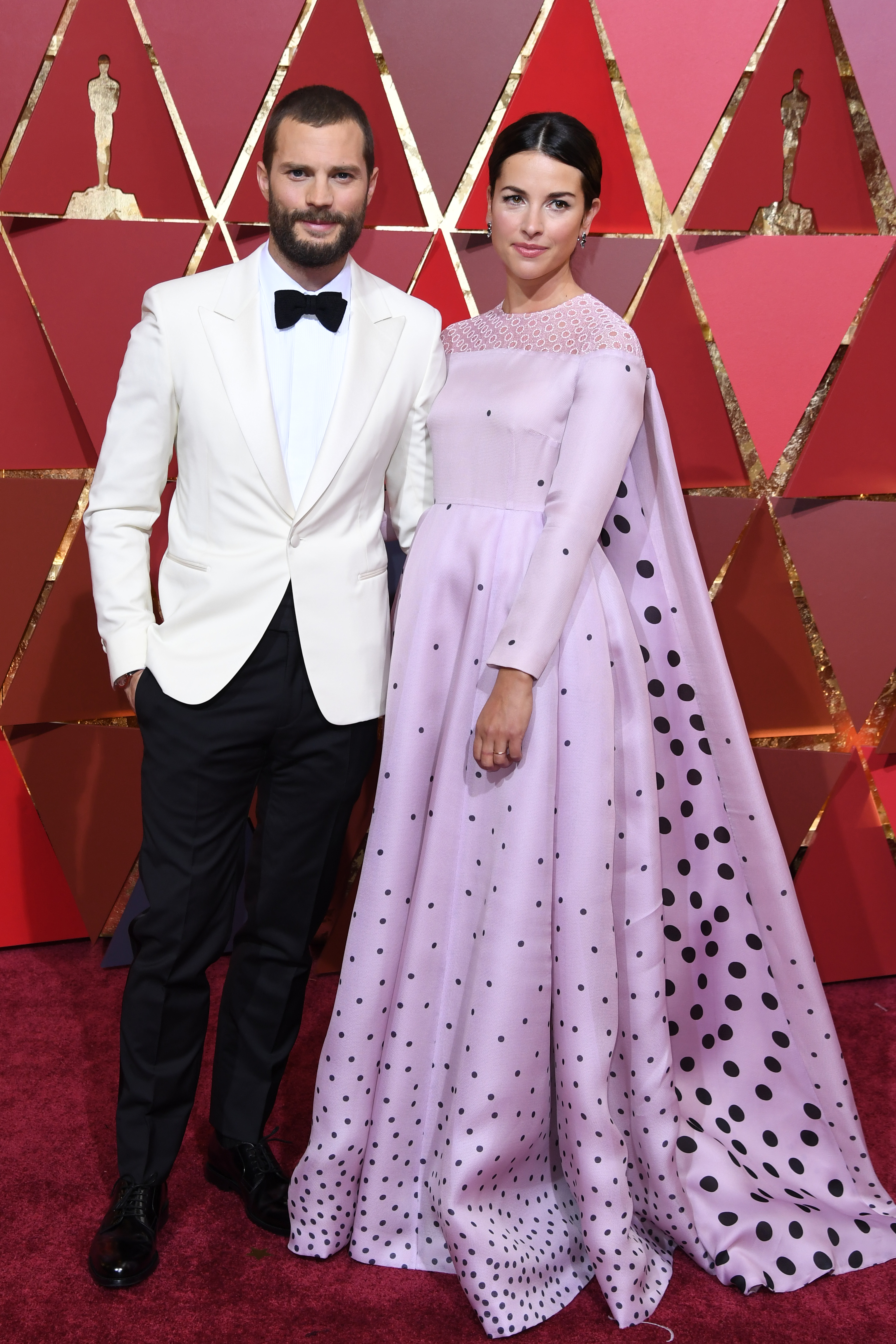 British actor Jamie Dornan (L) and his wife British actress Amelia Warner pose as they arrive on the red carpet for the 89th Oscars on February 26, 2017 in Hollywood, California.  / AFP PHOTO / ANGELA WEISS