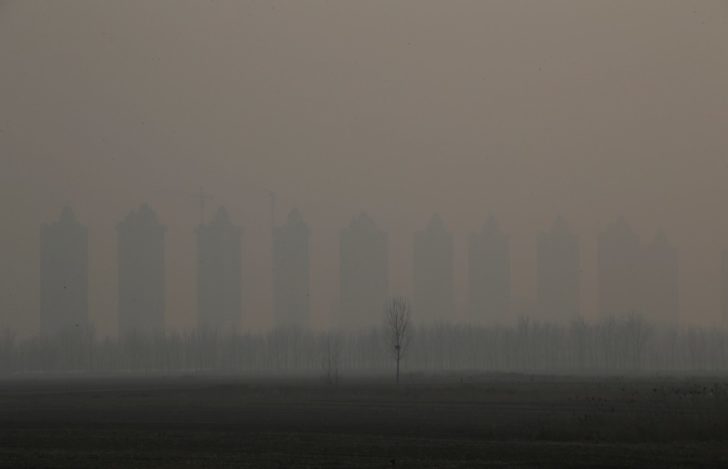 FILE PHOTO: Residential buildings under construction are pictured on a polluted day on the outskirts of Langfang