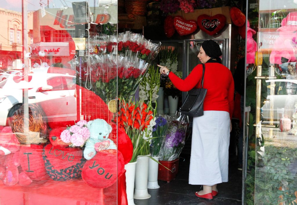 An Iraqi woman buys flowers on the eve of Valentine's Day in Baghdad's al-Mansour area on February 13, 2017. / AFP PHOTO / SABAH ARAR