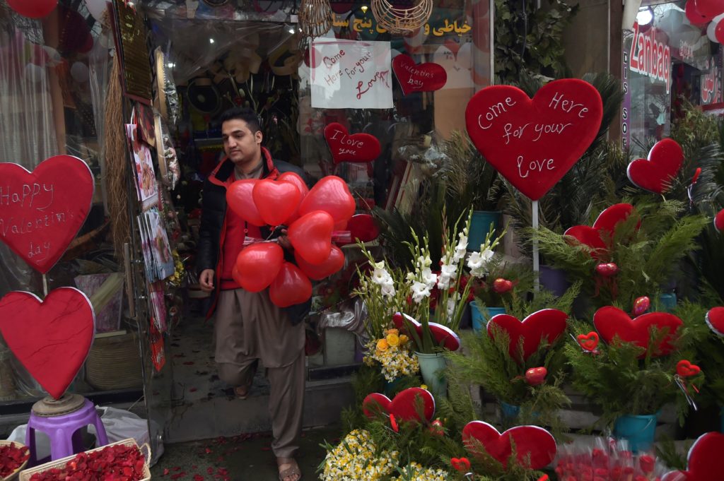 An Afghan resident leaves a shop carrying heart-shaped balloons on Valentine's Day in Kabul on February 14, 2017. In conservative Afghanistan, many Afghans are unaware of or don't mark Valentine's Day, but younger generations in urban areas are celebrating the day despite restrictions. / AFP PHOTO / SHAH MARAI
