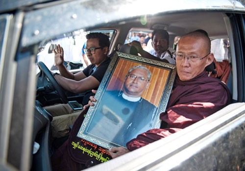 พระสงห์ถือรูปของอูโกนีนำขบวนแห่ศพ (ภาพจาก The Myanmar Times)