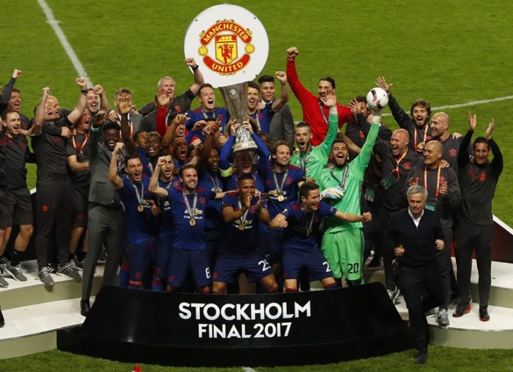 Manchester United's Wayne Rooney lifts the trophy as his team mates celebrate
