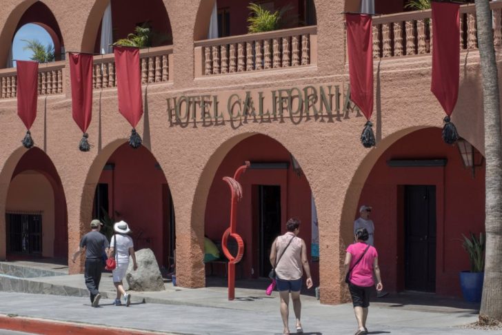 Tourists walk past Hotel California in the town of Todos Santos