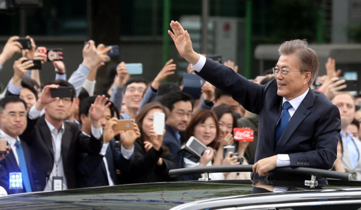 South Korean President Moon Jae-in waves in a car as he heads to the presidential Blue House after inaugural ceremony in Seoul
