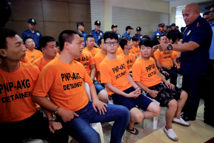 Philippine National Police (PNP) Chief Ronald Dela Rosa confronts some of the 43 arrested foreigners for kidnapping a Singaporean woman at a casino resort in the capital, during a presentation inside the PNP Headquarters in Quezon City