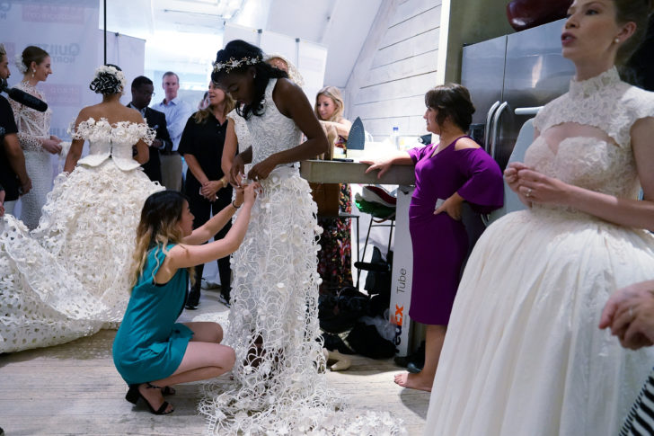 A designer is pictured backstage fixing a wedding dress made out of toilet paper before a fashion show in the Manhattan borough of New York City