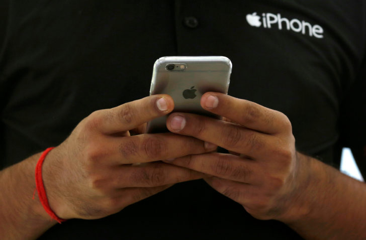 FILE PHOTO: A salesman uses his iPhone at a mobile phone store in New Delhi