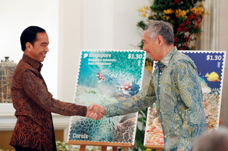 Indonesia's President Joko Widodo and Singapore's Prime Minister Lee Hsien Loong unveil a joint stamp issue at the Istana in Singapore