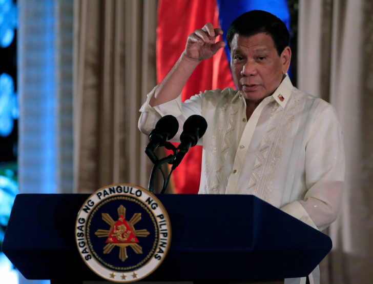 Duterte gestures as he delivers his speech during the oath taking of PNP star rank officers in Manila