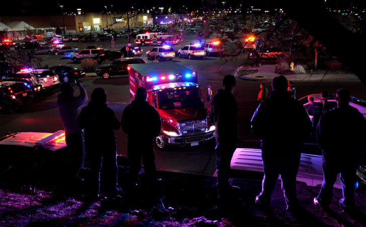 People watch an ambulance leave at the scene of a shooting at a Walmart in Thornton