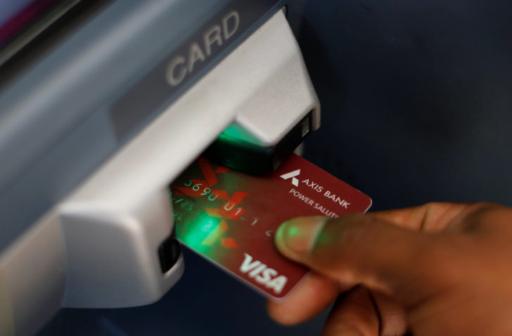 A man uses an Axis Bank automated teller machine (ATM) card in Mumbai