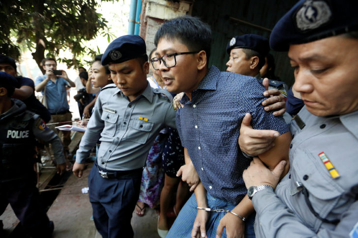 Detained Reuters journalist Wa Lone is escorted by police after a court hearing in Yangon