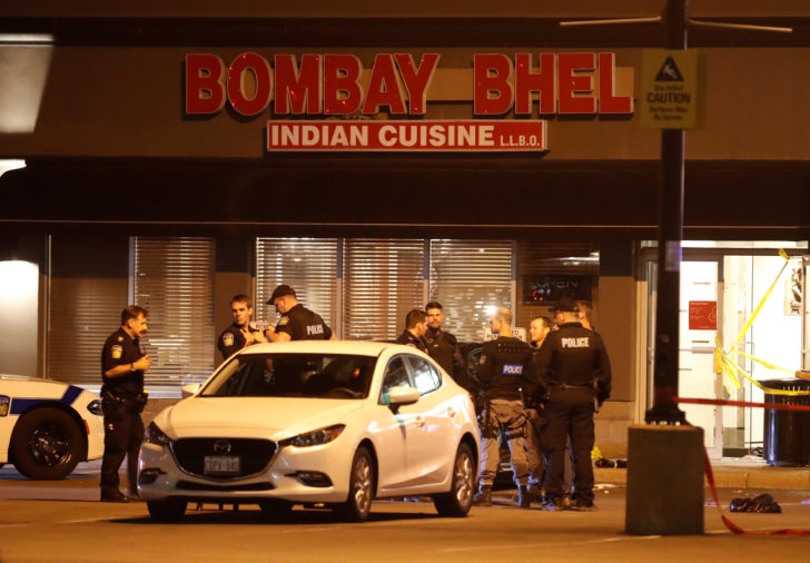 Police officers stand in front of Bombay Bhel restaurant, where two unidentified men set off a bomb, in Mississauga