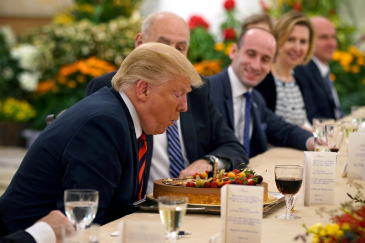U.S. President Donald Trump blows out the candle on his birthday cake as he attends a lunch with Singapore's Prime Minister Lee Hsien Loong at the Istana in Singapore