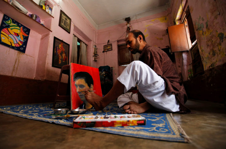 Ranjan Kurmi, 32, a fan of Argentina's football team paints footballer Lionel Messi's image on a canvas ahead of FIFA World Cup 2018 Group D match between Argentina and Iceland, inside a house on the outskirts of Kolkata
