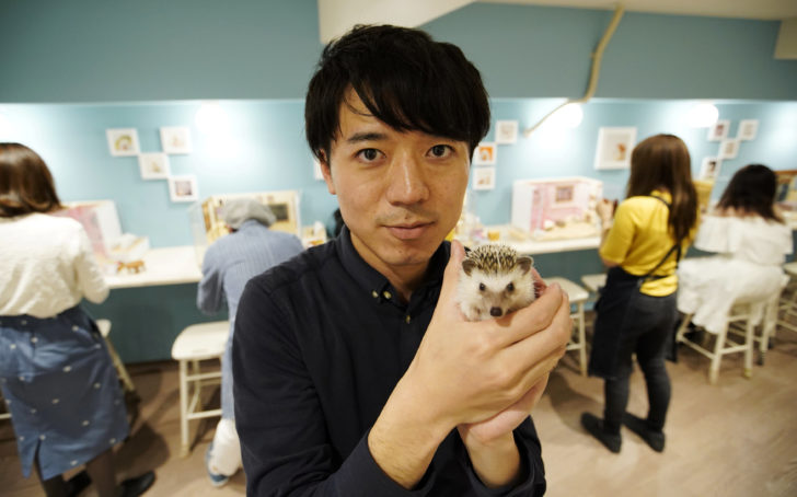 Masaki Shimizu poses with a hedgehog at his ChikuChiku cafe in Tokyo