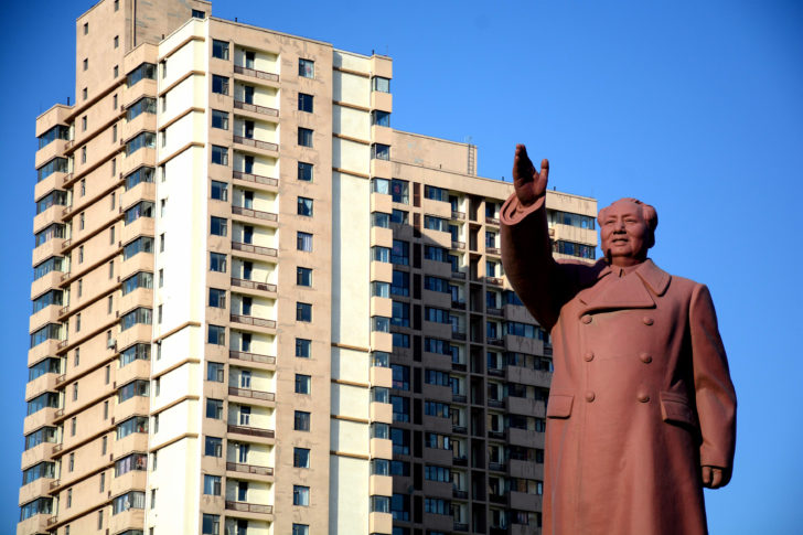 Statue of former Chinese chairman Mao Zedong is seen in front of a residential building in Dandong New Zone