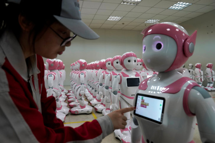 A worker puts finishing touches to an iPal social robot, designed by AvatarMind, at an assembly plant in Suzhou