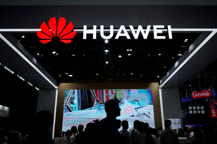 FILE PHOTO: People walk past a Huawei sign at CES (Consumer Electronics Show) Asia 2018 in Shanghai