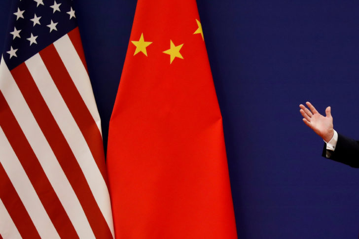 FILE PHOTO: FILE PHOTO: U.S. President Donald Trump delivers his speech next to U.S. and Chinese flags as he and Chinese President Xi Jinping meet business leaders at the Great Hall of the People in Beijing