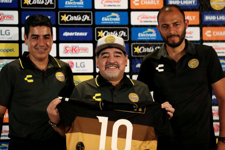 Argentinian soccer legend Diego Maradona poses with the uniform of the Dorados football club during a news conference where he is presented as the new head coach of the club, in Culiacan