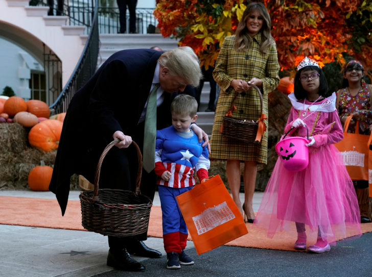 U.S. President Donald Trump and U.S. first lady Melania Trump hand out Halloween candy to trick-or-treaters at the White House in Washington
