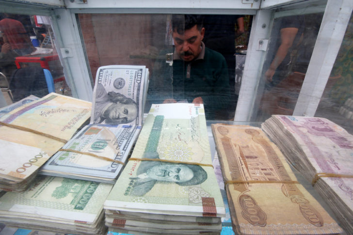 A man counts Iranian rials at a currency exchange shop, before the start of the U.S. sanctions on Tehran, in Basra