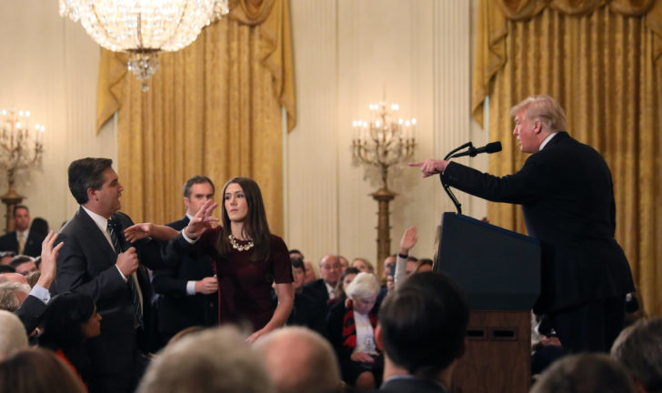 A White House staff member reaches for the microphone held by CNN's Jim Acosta as he questions U.S. President Donald Trump during a news conference in Washington