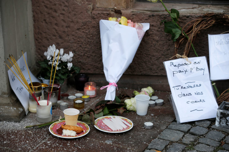 Flowers and candles are seen in a street in tribute to a Thai tourist who was killed during a shooting attack in Strasbourg