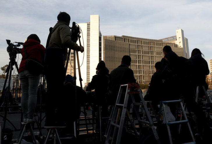 Members of media crews are seen on step ladders in front of the Tokyo Detention Center, where Nissan's arrested chairman Carlos Ghosn and a former Nissan executive Greg Kelly are being held, in Tokyo