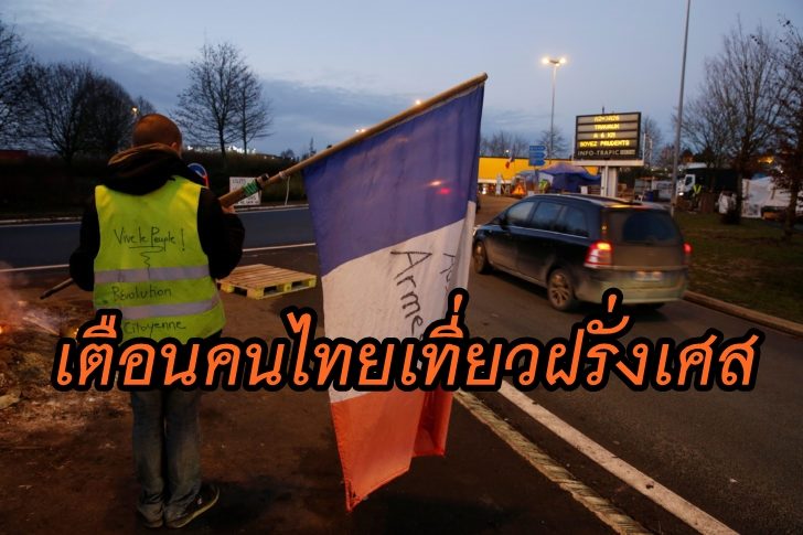A protester wearing a yellow vest, the symbol of a French drivers' protest against higher fuel prices, holds a flag at the approach to the A2 Paris-Brussels Motorway, in Fontaine-Notre-Dame