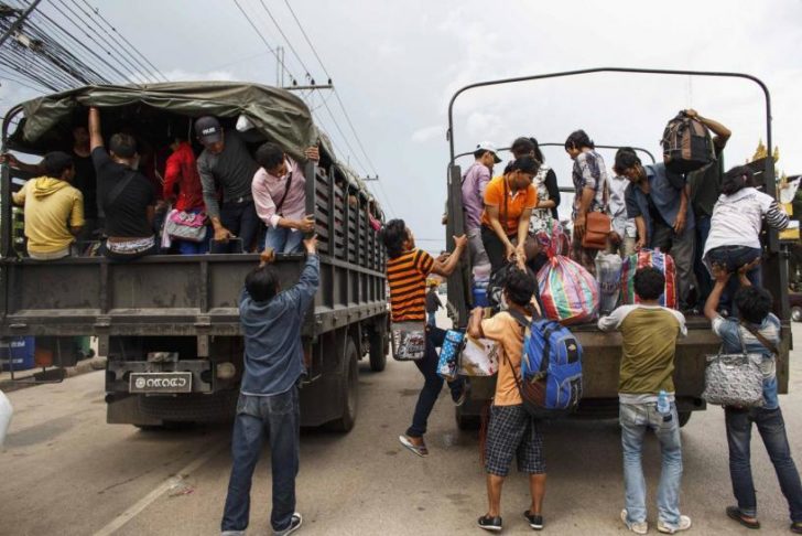 Cambodian workers ride on military trucks as they prepare to cross Thai-Cambodia border at Aranyaprathet in Sa Kaew