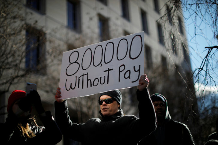 FILE PHOTO: Demonstrator holds a sign protesting the partial U.S. government shutdown