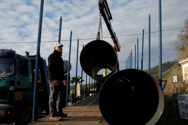 Workers move steels tubes, which will be used to protect a deep well, next to the area where Julen, a Spanish two-year-old boy fell into the well four days ago when the family was taking a stroll through a private estate, in Totalan