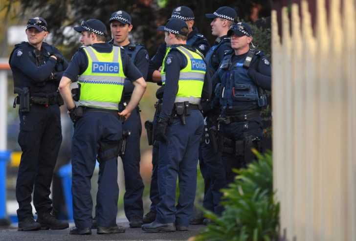 Australian police stand at the site of a siege at the Buckingham Serviced Apartments in Melbourne, Australia