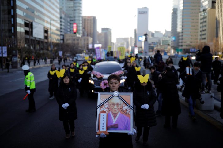 People march during the funeral of a former South Korean