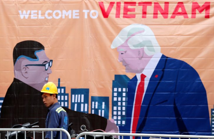 A man walks past a banner depicting North Korean leader Kim Jong Un and U.S. President Donald Trump ahead of the North Korea-U.S. summit in Hanoi