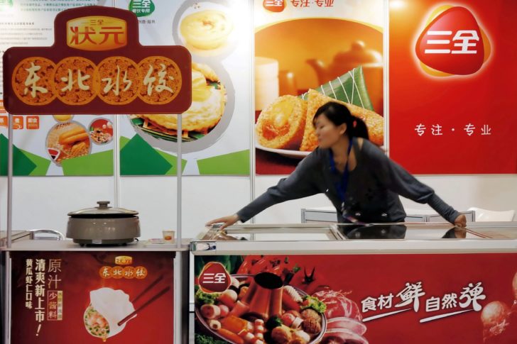 Staff member is seen at the booth of Sanquan Food promoting its dumpling products at a food fair in Shanghai