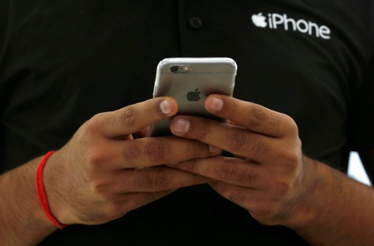 FILE PHOTO: A salesman uses his iPhone at a mobile phone store in New Delhi