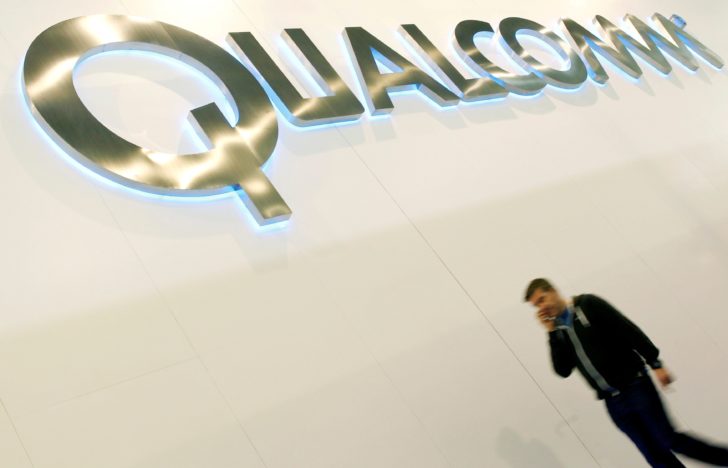 FILE PHOTO: A man walks past a Qualcomm advertising logo at the Mobile World Congress at Barcelona