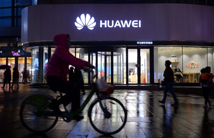 Woman cycles past a Huawei store in Shenyang
