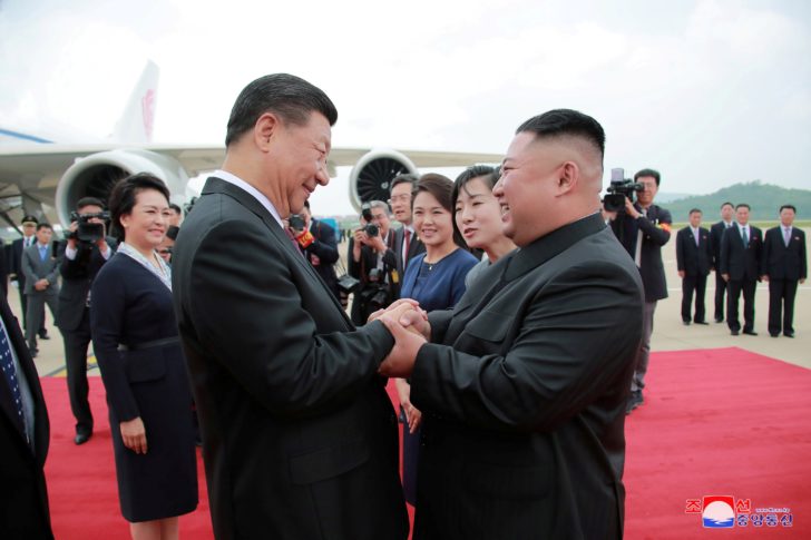North Korean leader Kim Jong Un welcomes Chinese President Xi Jinping at the Pyongyang International Airport in Pyongyang