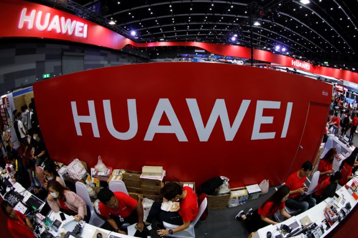 Workers sit at the Huawei stand at the Mobile Expo in Bangkok