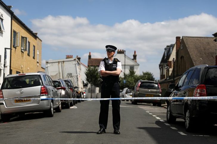 FILE PHOTO: A police officer stands at the cordon on the street where a heavily pregnant woman was stabbed to death in the Thornton Heath area of London