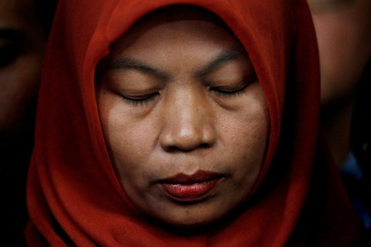 FILE PHOTO: Baiq Nuril Maknun, a teacher on the island of Lombok who was jailed after she tried to report sexual harassment, reacts during a press conference with Indonesia's Law and Human Rights Minister Yasonna Laoly in Jakarta