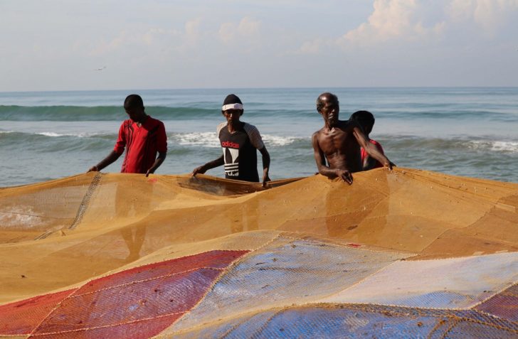 Fishermen pull their fishing net on a beach, in Colombo