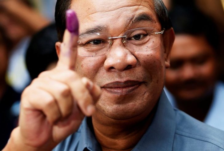 FILE PHOTO: Cambodia's PM Hun Sen shows his ink-stained finger after casting a vote in the general elections at a polling station in Kandal province